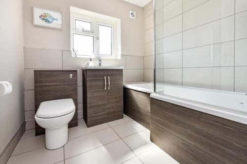 a bathroom with a toilet and a tub and a sink at 3 Bed in Abersoch oc-16maes in Abersoch