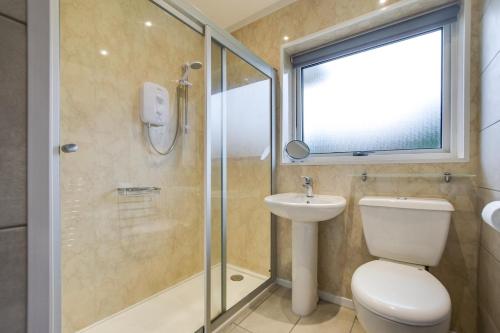 a bathroom with a shower and a toilet and a sink at 2 Bed in Port Eynon oc-hh2104 in Port-Eynon