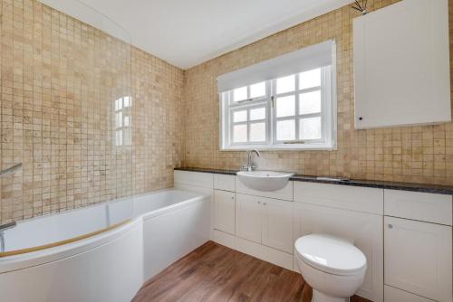 a bathroom with a toilet and a sink and a tub at 4 Bed in Saxmundham oc-oth in Dunwich