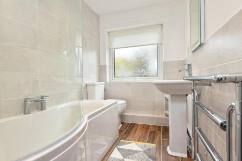 a white bathroom with a tub and a sink at 2 Bed in Abersoch oc-147cae in Abersoch