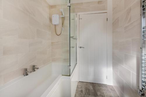 a bathroom with a shower and a tub and a sink at 2 Bed in Abersoch oc-23caed in Abersoch