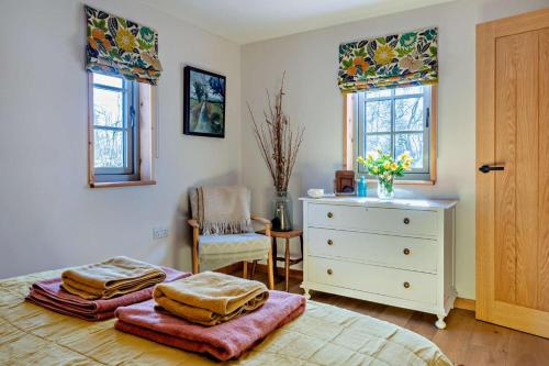 a bedroom with a bed and a dresser and windows at 1 Bed in Builth Wells oc-p27441 in Builth Road