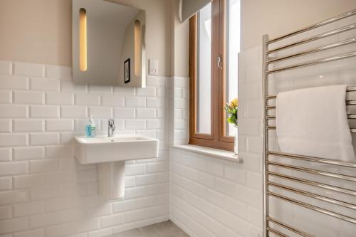 a white bathroom with a sink and a window at 7 Bed in Aldeburgh oc-midba in Aldeburgh