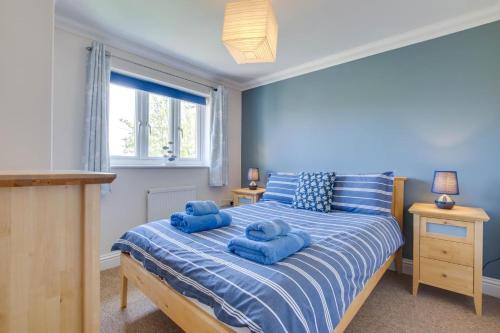 a bedroom with two blue towels on a bed at 3 Bed in Southwold oc-fie2 in Reydon