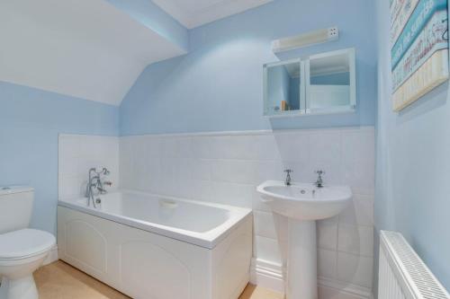 a white bathroom with a sink and a toilet at 3 Bed in Southwold oc-fie2 in Reydon