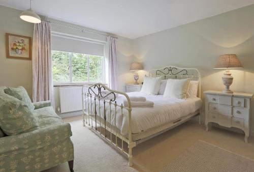 a bedroom with a bed and a chair and a window at 4 Bed in Walberswick oc-ltm in Walberswick