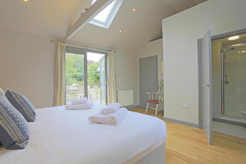 a bedroom with a white bed with towels on it at 4 Bed in Walberswick oc-ltm in Walberswick