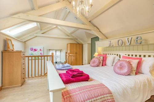 a bedroom with a large bed with pink pillows at 1 Bed in Bodmin oc-p00438 in Bodmin