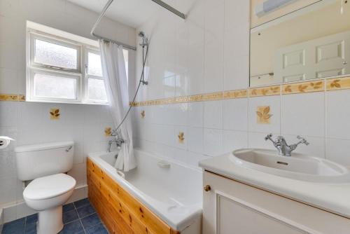 a white bathroom with a sink and a toilet at 4 Bed in Southwold oc-spn in Reydon
