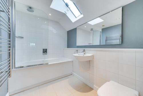 a bathroom with a tub and a sink and a mirror at 6 Bed in Knodishall oc-bil in Aldringham