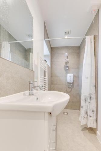 a white bathroom with a sink and a shower at 1 Bed in Great Waldingfield oc-ac1 in Waldingfield
