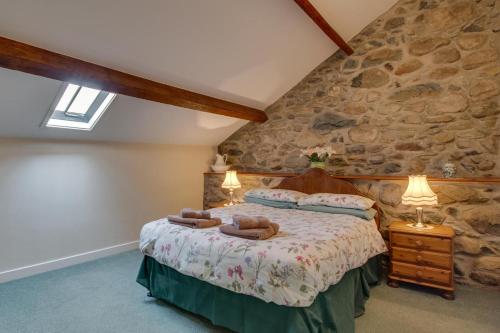 a bedroom with a bed in a stone wall at 2 Bed in Barmouth oc-wah699 in Talybont