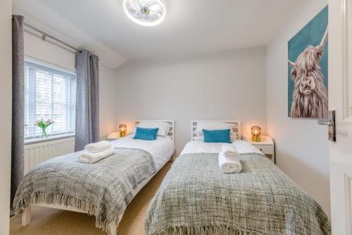 two beds in a bedroom with blue pillows at 2 Bed in Alnwick oc-e33447 in Embleton