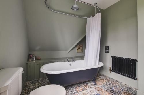 a bathroom with a tub and a toilet and a sink at 3 Bed in Walberswick oc-spinn in Walberswick