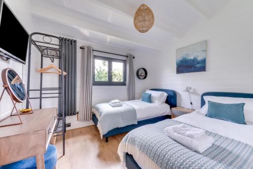 a bedroom with two beds and a desk and a tv at 2 Bed in Stradbroke oc-wopl in Stradbroke