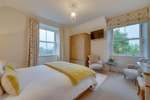 a bedroom with a large white bed and windows at 4 Bed in Brithdir oc-wag722 in Cross Foxes