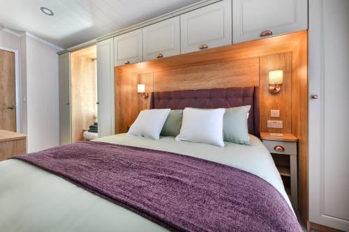 a bedroom with a large bed with a wooden headboard at 2 Bed in Abersoch oc-atacam in Abersoch