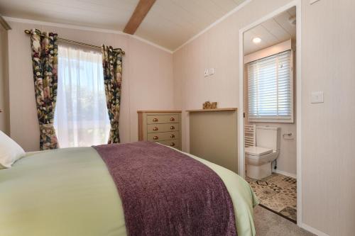 a bedroom with a bed and a toilet and a window at 2 Bed in Abersoch oc-atacam in Abersoch