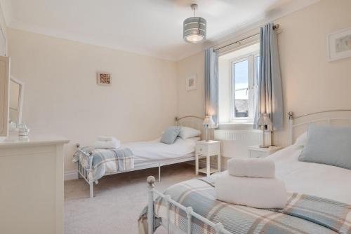 a white bedroom with two beds and a window at 3 Bed in Trimingham oc-2290 in Trimingham