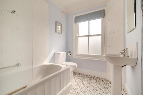 a white bathroom with a tub and a sink at 4 Bed in Southwold oc-l29092 in Southwold