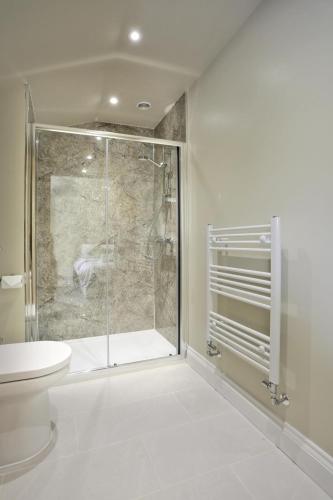 a bathroom with a glass shower and a toilet at 10 Bed in Barsham oc-rrest in Beccles