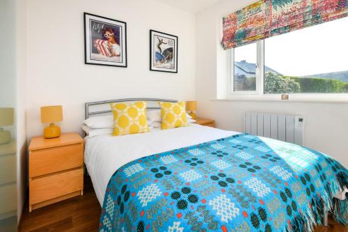 a bedroom with a large bed and a window at 3 Bed in Pwllheli oc-hillvi in Llanbedrog