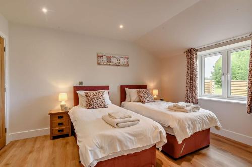 a bedroom with two beds and a window at 10 Bed in Barsham oc-rrest in Beccles