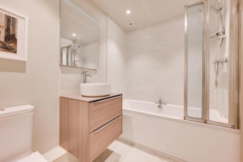 a white bathroom with a sink and a bath tub at 1 Bed in Middleton oc-rosc in Middleton