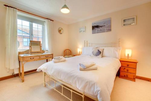 a bedroom with a bed and a desk with a computer at 2 Bed in Sheringham oc-2029 in Sheringham