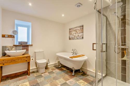 a bathroom with a tub and a sink and a toilet at 3 Bed in Outwell oc-b28260 in Upwell
