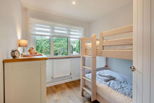 a bedroom with two bunk beds and a window at 3 Bed in Acton oc-c28929 in Waldingfield