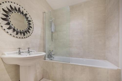 a bathroom with a sink and a tub and a mirror at 1 Bed in Nefyn oc-n28983 in Nefyn