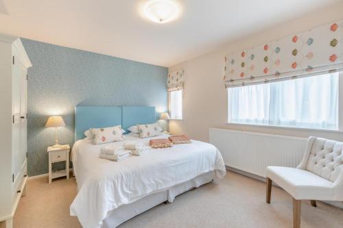 a bedroom with a white bed and a chair and a window at 2 Bed in Bamburgh oc-gd0462 in Bamburgh