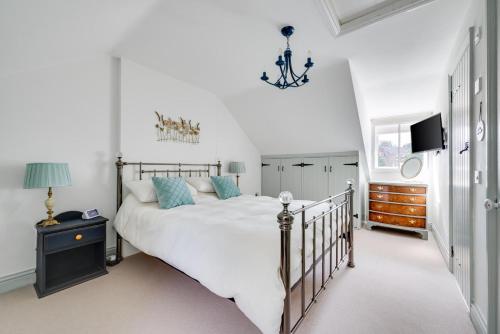 a bedroom with a large white bed and a chandelier at 4 Bed in Halesworth oc-5river in Halesworth