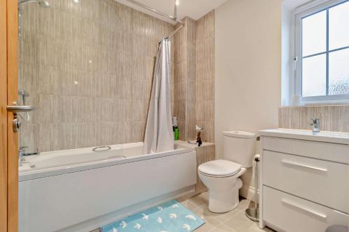 a bathroom with a tub and a toilet and a sink at 3 Bed in Framlingham oc-f30353 in Framlingham