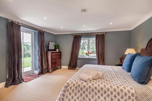 a bedroom with a large bed and windows at 1 Bed in Wymondham oc-e32664 in Wymondham
