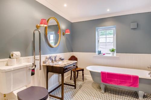 a bathroom with a tub and a sink and a mirror at 1 Bed in Wymondham oc-e32664 in Wymondham