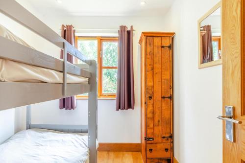 a small bedroom with a bunk bed and a window at 3 Bed in Shebbear oc-l32583 in Shebbear