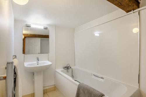 a white bathroom with a sink and a bath tub at 2 Bed in Smallburgh oc-m33732 in Dilham
