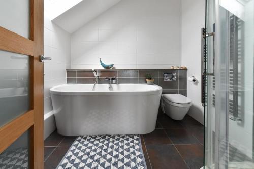 a bathroom with a large tub and a toilet at 4 Bed in Abersoch oc-egrypo in Abersoch