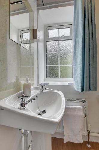 a white sink in a bathroom with a window at 2 Bed in Westward Ho oc-n0987 in Westward Ho