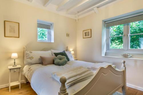 a bedroom with a white bed and two windows at 2 Bed in Chideock oc-h29331 in Chideock