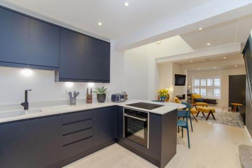 a kitchen with blue cabinets and a living room at 2 Bed in Bath oc-bhr8 in Bath