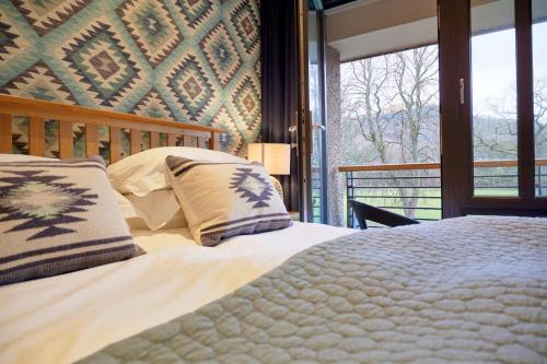 a bedroom with a bed and a large window at Riverside Park 5 in Keswick