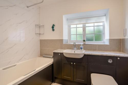 a bathroom with a tub and a sink and a bath tubermottermott at 3 Bed in Scethrog oc-h30013 in Scethrog