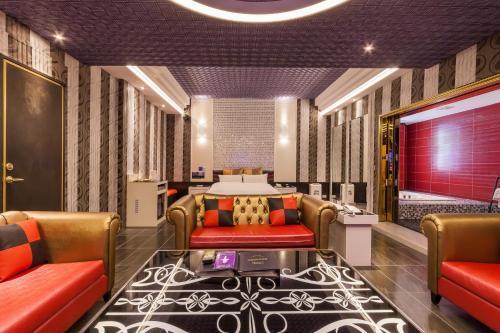 a hotel room with a bed and two chairs at Soho Motel in Taoyuan