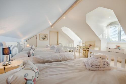a group of white beds in a room at 5 Bed in Rock oc-m33185 in Roche