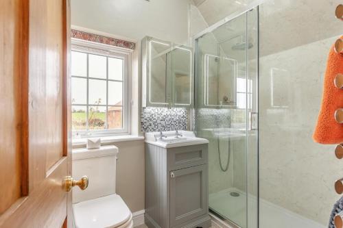 a bathroom with a shower and a toilet and a sink at 3 Bed in Fulbeck oc-v33643 in Fulbeck