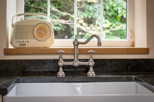 a kitchen sink with a toaster next to a window at 5 Bed in Kettlewell oc-ds257 in Kettlewell