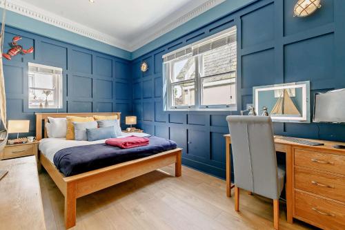 a blue bedroom with a bed and a desk at 1 Bed in Fowey oc-m27634 in Fowey